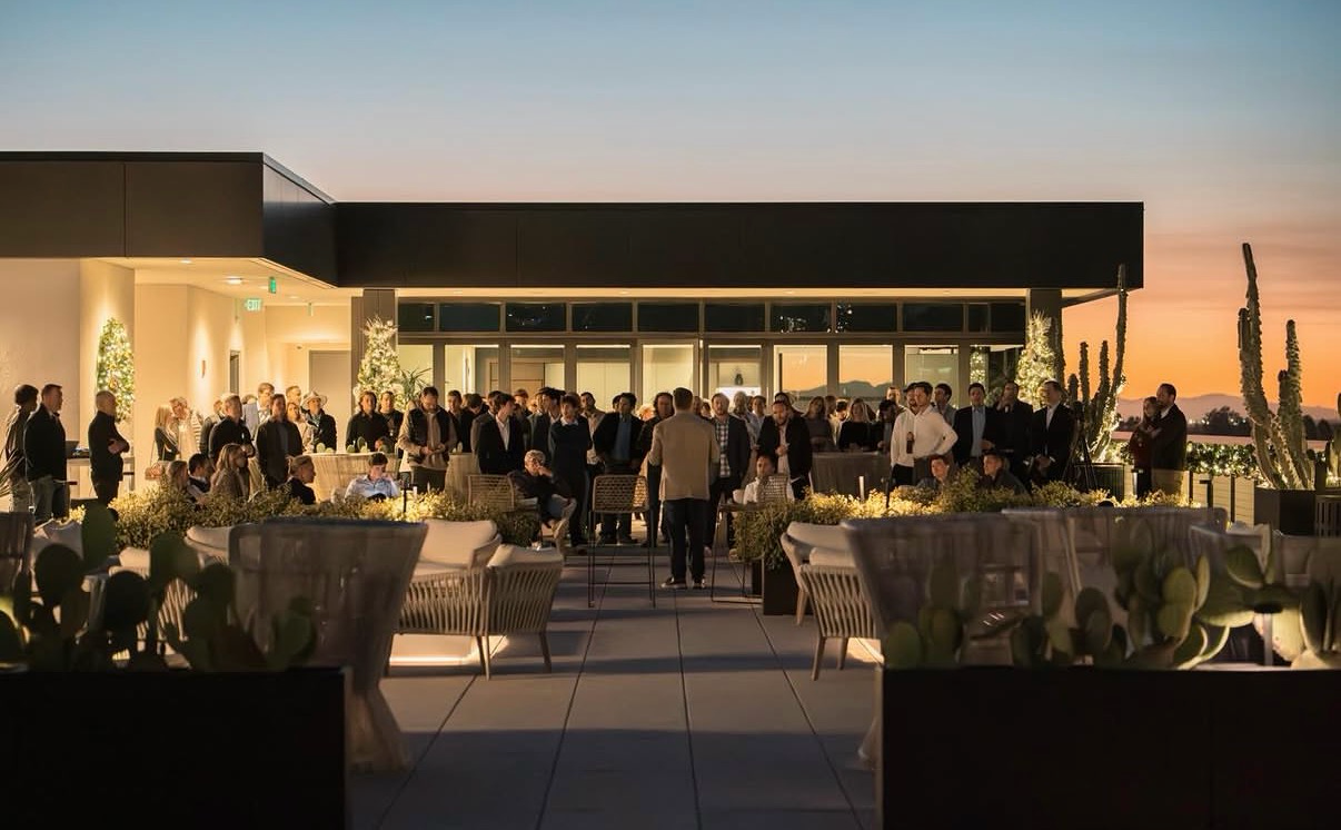 Guests gathered on a rooftop terrace at sunset for a nameless evening